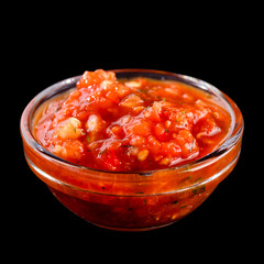 Red hot sauce from chilli peppers and tomatoes in small glass bo