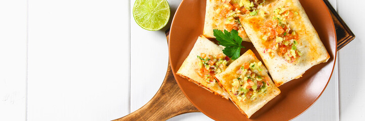 Traditional Mexican dish - chimichanga. Corn cake with minced meat, pepper, onion, garlic, oregano, zira and guacomole sauce from avocado.