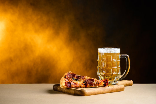 Slice of delicious homemade pizza served with light cold beer on