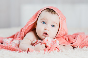 Baby after shower in pink or peach towel on head