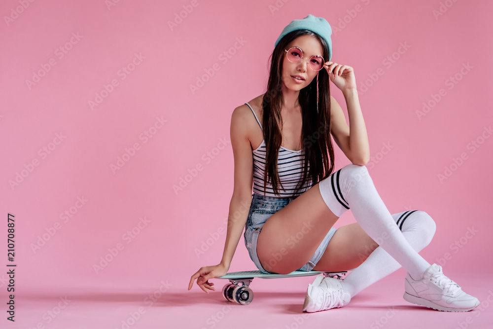 Wall mural Young girl on pink background