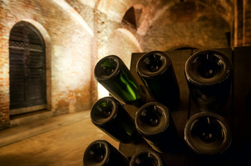 Pupitre and bottles inside an underground cellar for the production of traditional method sparkling...