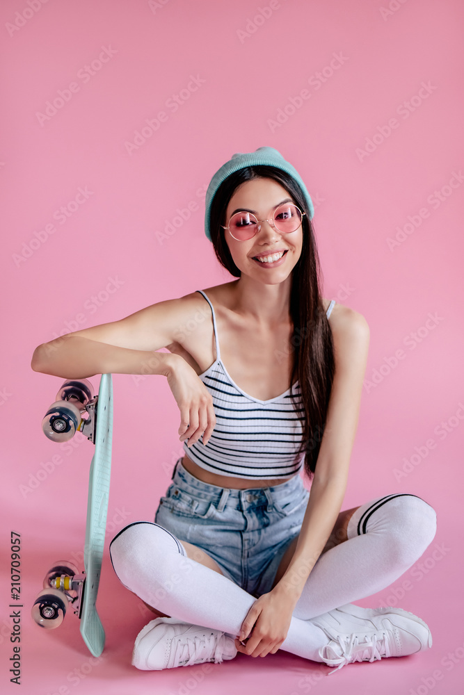 Wall mural Young girl on pink background