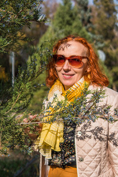 55 Year Old Woman In Autumn Park With Colored Leaves