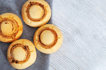 Shortbread cookies in form of champignons. Baked sweet biscuits on wooden with copy space. Delicious dessert. Top view.