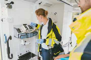 Paramedic using medical technology in ambulance car to help © Kzenon