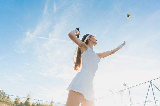 Woman serving the ball for a game of tennis on court