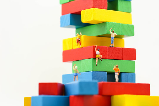 Miniature people : climbing colorful wooden block with challenging route on cliff, Concept of the path to purpose and success.