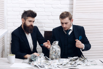 Business partners, businessmen at meeting in office. Cash issues concept. Colleagues collecting money in jar instead of bank account. Manager with beard and colleague with jar of cash