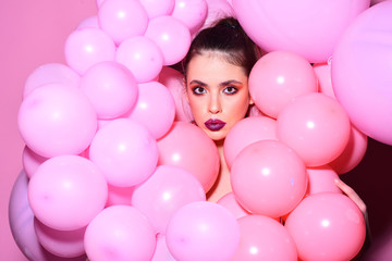 Fototapeta na wymiar Balloon party on pink studio background. Fashion woman with many pink air balloons. Retro girl with stylish makeup and hair. Birthday decor and celebration. girl dreaming in punchy pastels trend