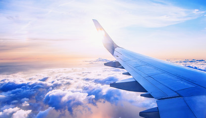 Fliegen und Reisen, Blick aus dem Flugzeugfenster auf dem Flügel bei Sonnenuntergang
