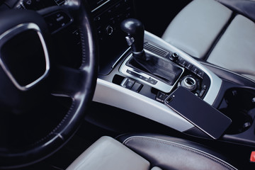 Fototapeta na wymiar smartphone with dual camera in the interior of a modern car