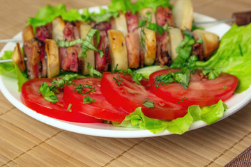 chicken kebab with bacon potatoes, herbs and tomatoes