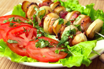 chicken kebab with bacon potatoes, herbs and tomatoes