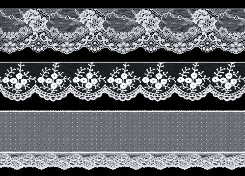 Set of three elegant white lace ribbons on a black background. Lace braid.