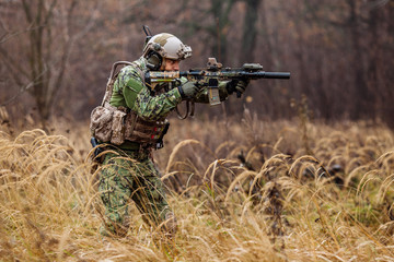 soldier with rifle in full gear. Military man on the background of nature.