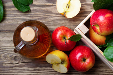 Naklejka na ściany i meble Apple cider vinegar and fresh red apple on a wooden background