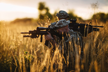 Rangers shooting with his weapon, rifle at sunset. War, army, military concept.