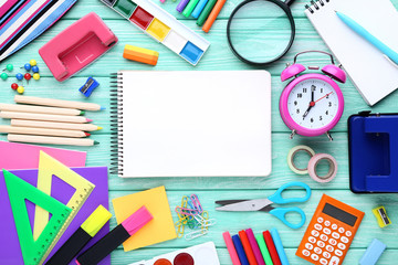 School supplies with blank sheet of paper on wooden table