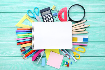 School supplies with blank sheet of paper on wooden table