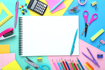School supplies with blank sheet of paper on colorful background