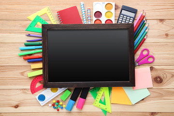 School supplies with black frame on wooden table