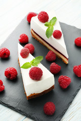 Tasty raspberries cheesecakes on cutting board
