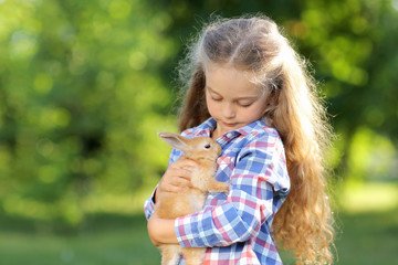 Girl with a cute little rabbit, outdoor, summer day