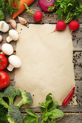 Blank brown paper with vegetables on wooden table