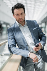 Fototapeta premium close up.businessman reading SMS standing in the airport building