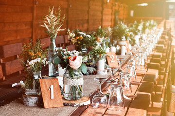 Table decor with white flowers and candles for a wedding party. Wedding in nature.