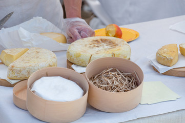 The seller on a marketplace sells handmade cheese, close-up