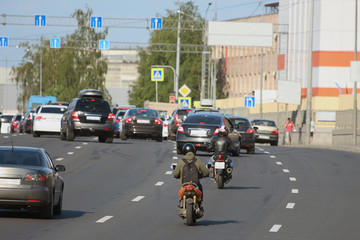 traffic of cars and motorcycles on a city street