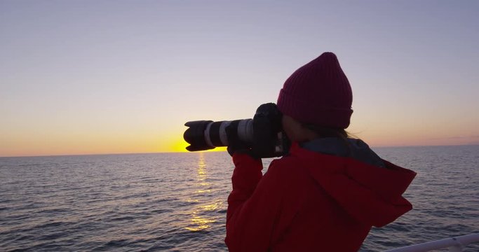 Iceland tourist photographer on harbour cruise and whale watching in Reykjavik. Woman taking pictures with SLR camera enjoying travel vacation. RED EPIC SLOW MOTION.,