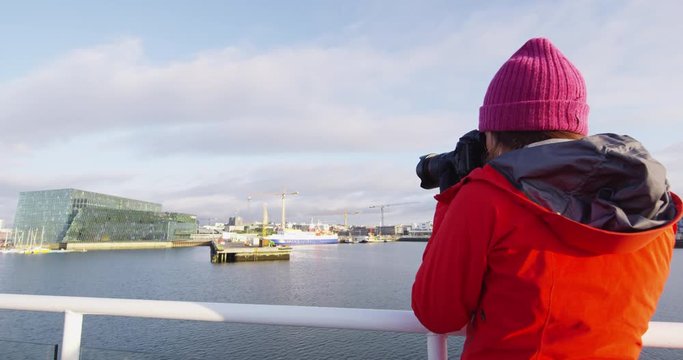 Iceland tourist photographer on harbour cruise and whale watching. Woman taking pictures with SLR camera enjoying travel vacation boat tour. RED EPIC SLOW MOTION.,