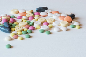 Different colorful medicines. Pills and capsules on white background. Copy space.