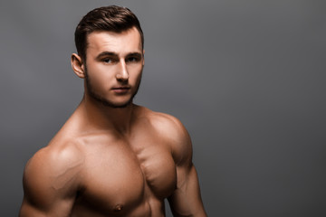 Fototapeta premium Young handsome muscular man bodybuilder posing in the studio