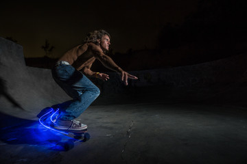 Shot of a guy skateboarding in a night skate park