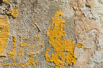 Textured grunge background. Volumetric plastered wall with a multilayer cracked coating. Orange chips on the whitewashed wall. Grunge texture with a deep pattern