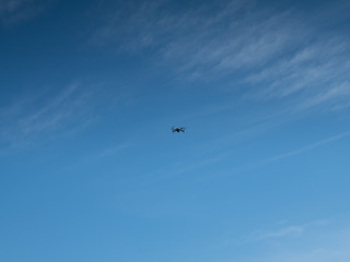 Drone hovers against a blue sky