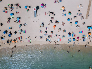 Aerial of People lying and playing on the beach during midday