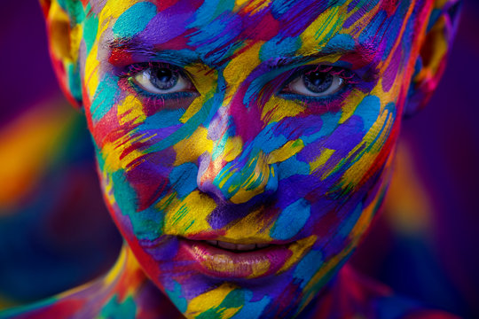 Portrait of the bright beautiful woman with art colorful make-up and bodyart