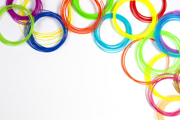 Colorful 3d pen filaments on white background, top view