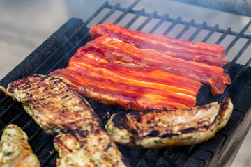 Assorted mixed grill from chicken meat, and pork, sausages  roasting on barbecue grid cooked for summer family dinner