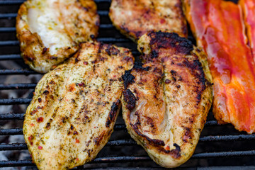 Assorted mixed grill from chicken meat, and pork, sausages  roasting on barbecue grid cooked for summer family dinner