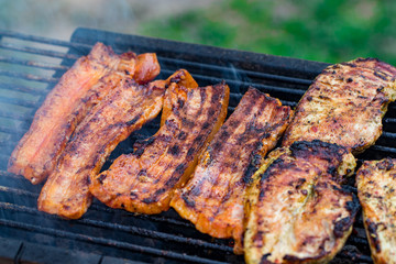 Assorted mixed grill from chicken meat, and pork, sausages  roasting on barbecue grid cooked for summer family dinner