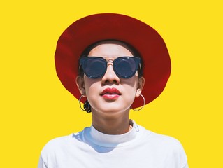 Portrait of young woman in hat and sunglasses