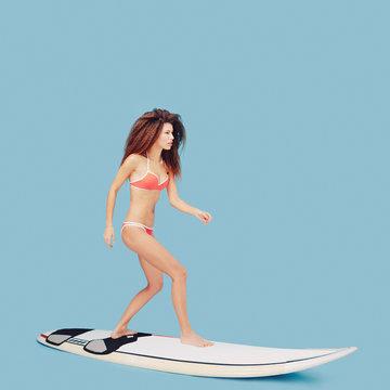 Beautiful girl standing on surfboard