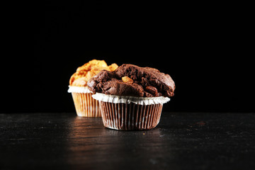 Chocolate muffin and nut muffin, homemade bakery on dark background.
