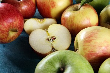 Ripe red apples with leaves on wooden background.